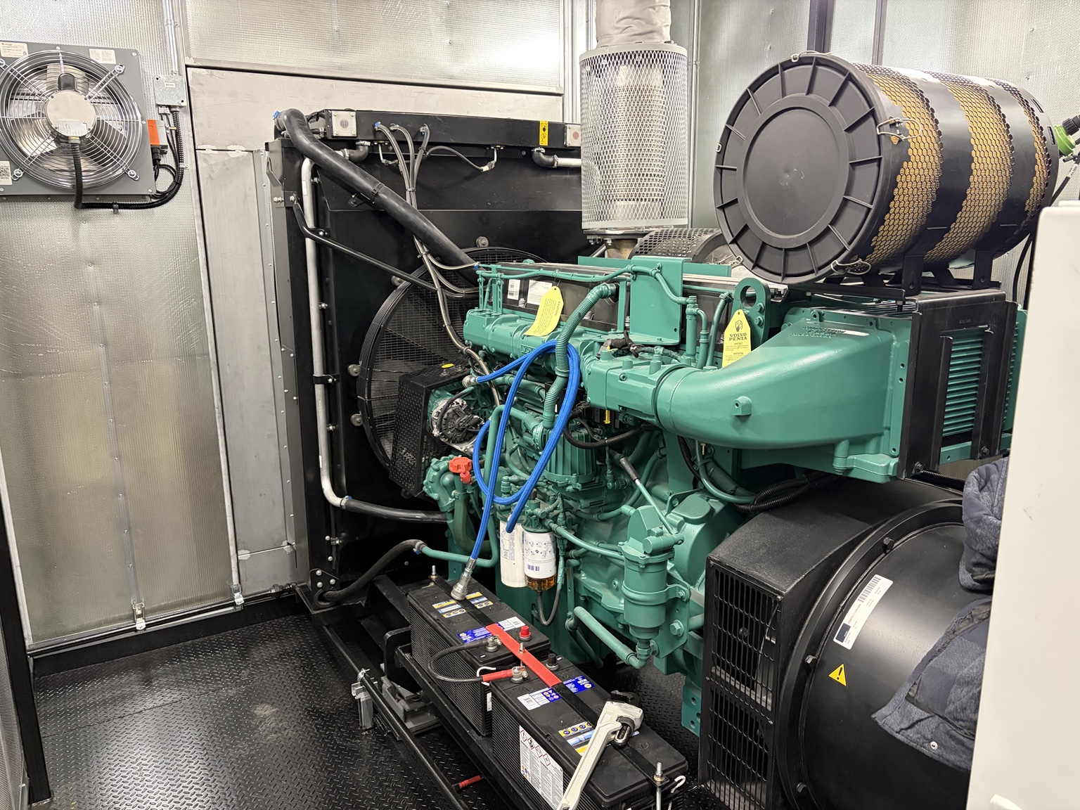 Green Volvo Penta diesel engine connected to a generator